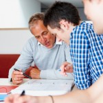 closeup of teacher helping male student with his work